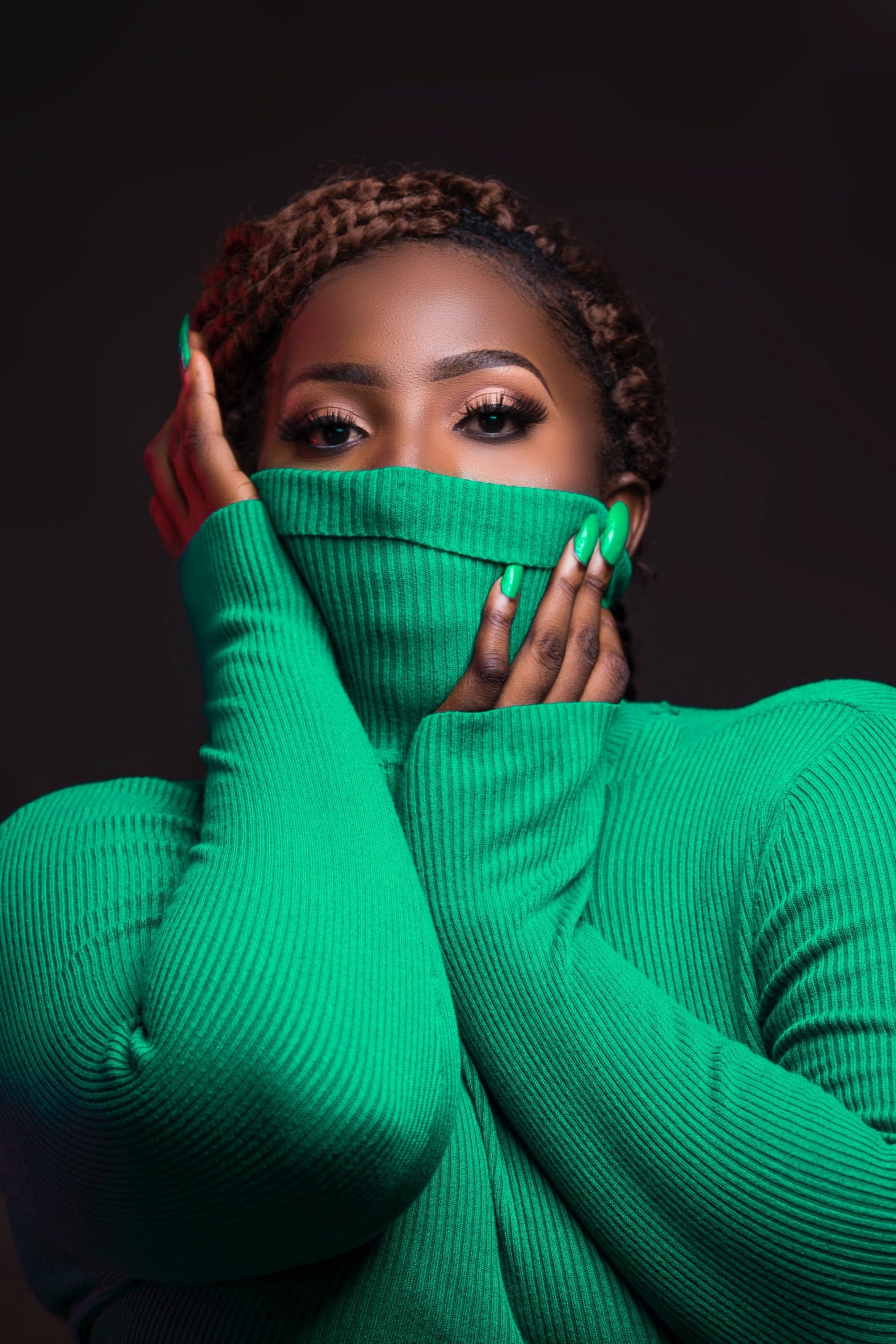 African Female Covering Mouth with Green Turtle Neck Sweater